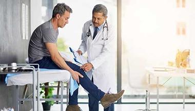 男子与医生讨论膝盖疼痛.