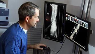 Dr. 詹姆斯·菲克在手术前看足部x光片
