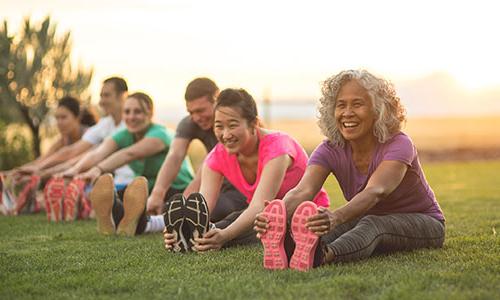 一群微笑的成年人在锻炼前伸展身体.