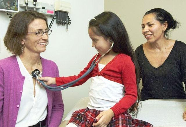 一个孩子在健康检查时用听诊器检查医生