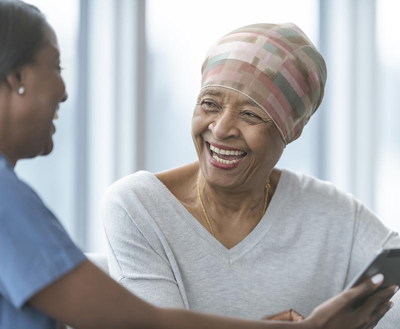 mature woman with cancer laughing with nurse